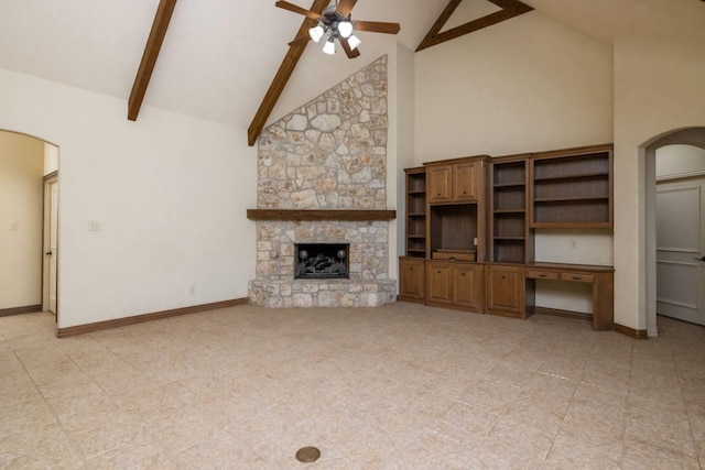 unfurnished living room featuring beam ceiling, high vaulted ceiling, ceiling fan, and a stone fireplace