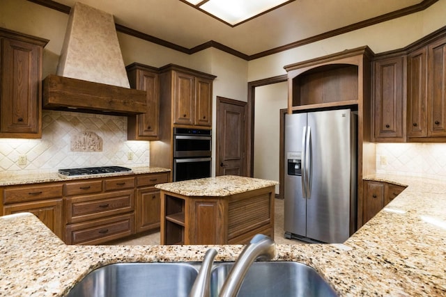 kitchen featuring light stone counters, crown molding, decorative backsplash, custom range hood, and appliances with stainless steel finishes