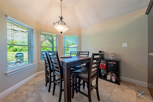 tiled dining area featuring vaulted ceiling