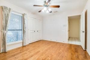 unfurnished bedroom with ceiling fan, hardwood / wood-style floors, and a closet