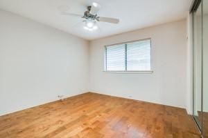 empty room with hardwood / wood-style floors and ceiling fan