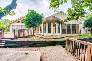 back of house featuring a wooden deck and a sunroom