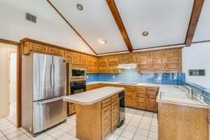 kitchen with sink, vaulted ceiling with beams, a center island, light tile patterned floors, and stainless steel appliances