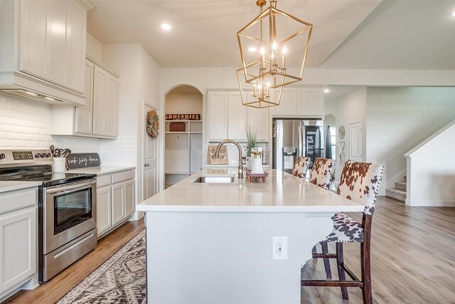 kitchen featuring sink, stainless steel appliances, and an island with sink