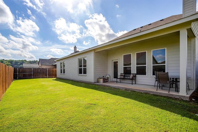 rear view of property featuring a lawn and a patio