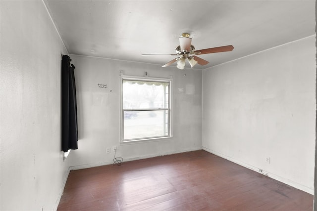 empty room with dark hardwood / wood-style flooring and ceiling fan