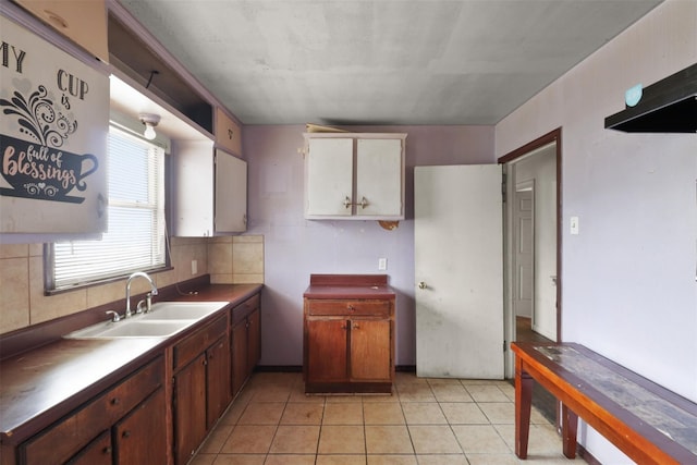 kitchen with decorative backsplash, sink, and light tile patterned floors