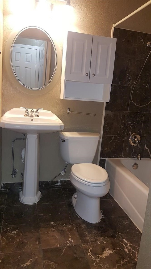 bathroom featuring bathtub / shower combination and toilet