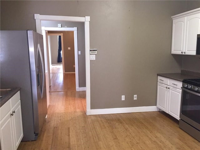 kitchen featuring stainless steel appliances, light hardwood / wood-style flooring, and white cabinetry