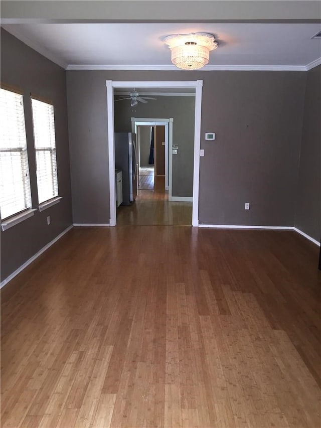 unfurnished room featuring ornamental molding, ceiling fan, and wood-type flooring