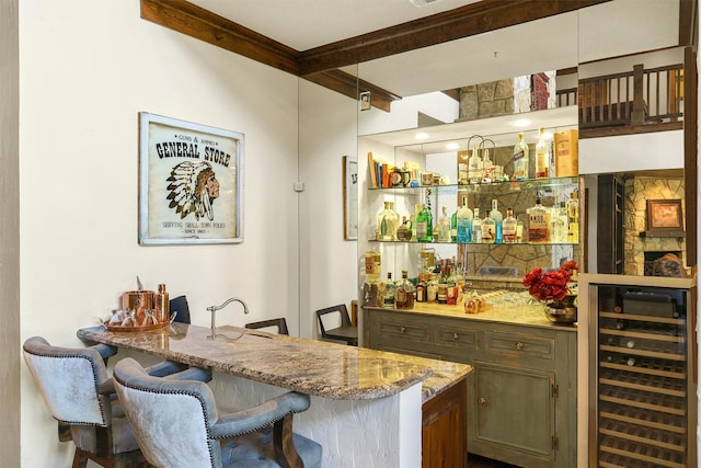 bar featuring beam ceiling, beverage cooler, light stone counters, and pendant lighting