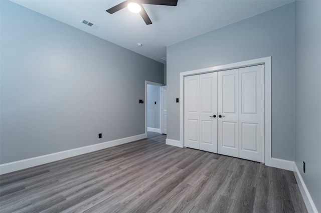 unfurnished bedroom featuring wood-type flooring, a closet, and ceiling fan