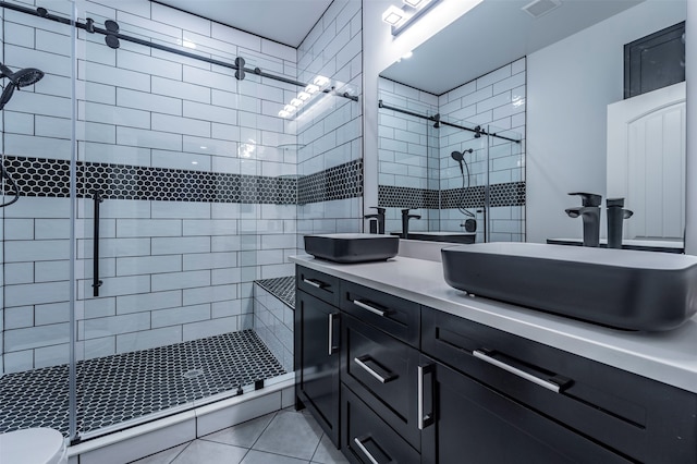 bathroom with tiled shower, tile flooring, toilet, and large vanity