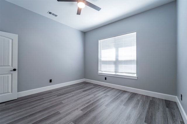 empty room featuring dark wood-type flooring and ceiling fan