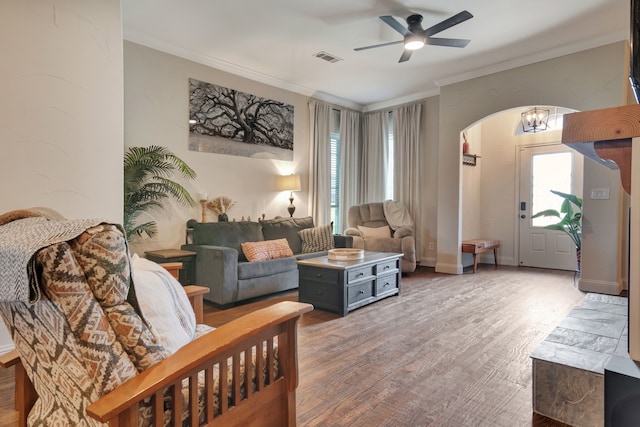 living room with ceiling fan, plenty of natural light, wood-type flooring, and ornamental molding