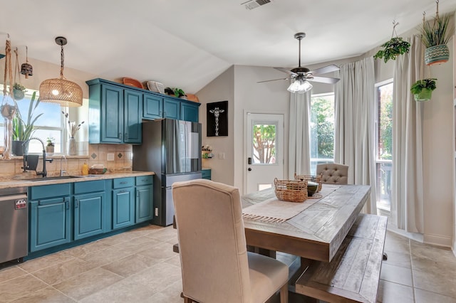 tiled dining area featuring vaulted ceiling, ceiling fan, and sink