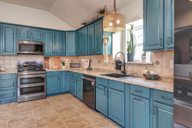 kitchen with appliances with stainless steel finishes, vaulted ceiling, blue cabinets, sink, and pendant lighting