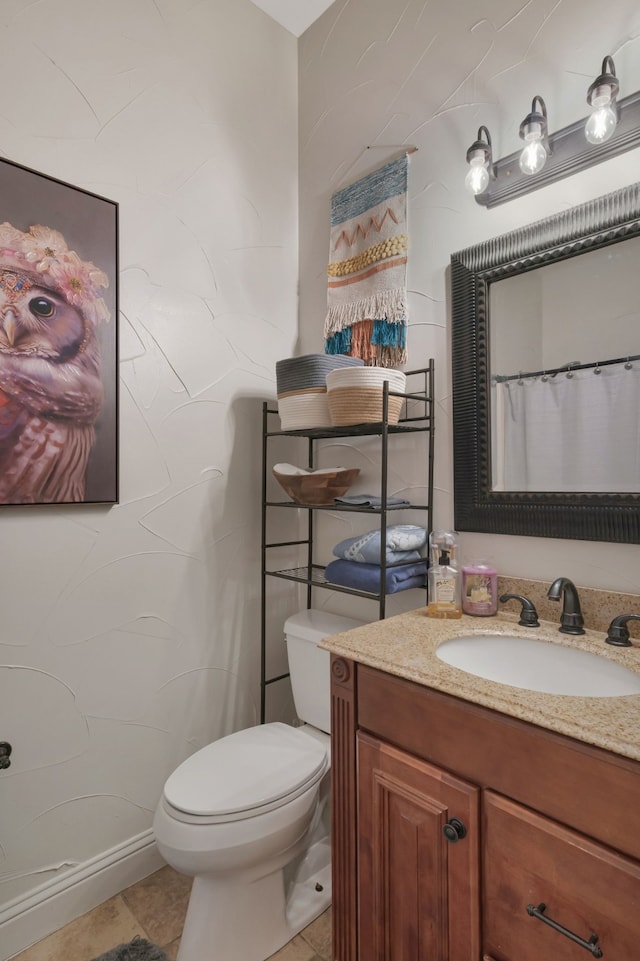 bathroom featuring tile patterned floors, vanity, and toilet