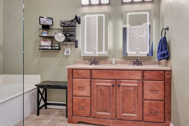 bathroom with tile patterned floors, a tub, and vanity