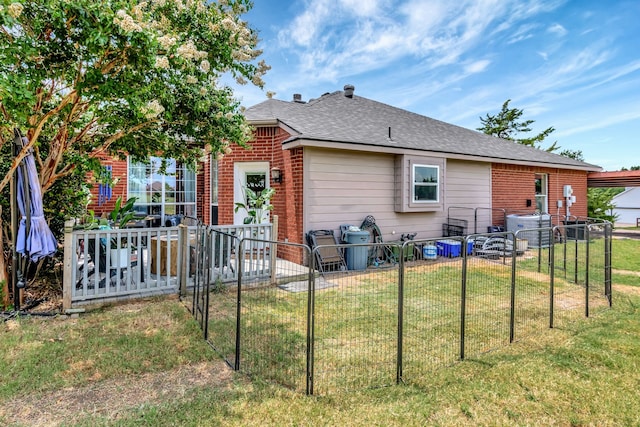 back of property featuring a deck, central AC unit, and a lawn