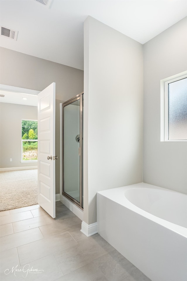 bathroom featuring plus walk in shower and tile patterned floors