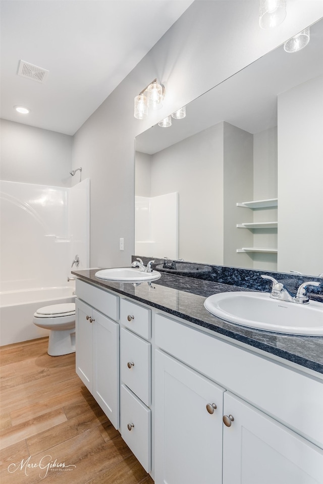 full bathroom featuring vanity, toilet, shower / bathtub combination, and hardwood / wood-style flooring