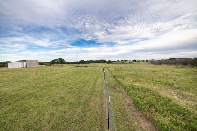 view of yard with a rural view and an outdoor structure