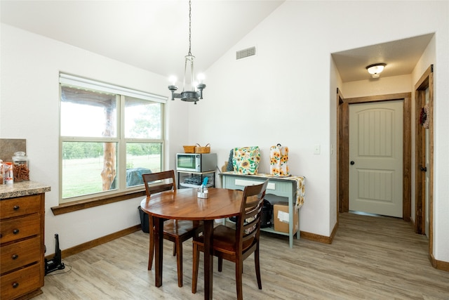 dining area featuring lofted ceiling, a chandelier, and light hardwood / wood-style flooring