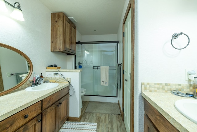 bathroom featuring vanity, toilet, an enclosed shower, and hardwood / wood-style flooring