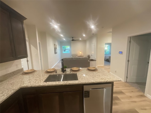 kitchen with dark brown cabinets, sink, dishwasher, and light stone countertops