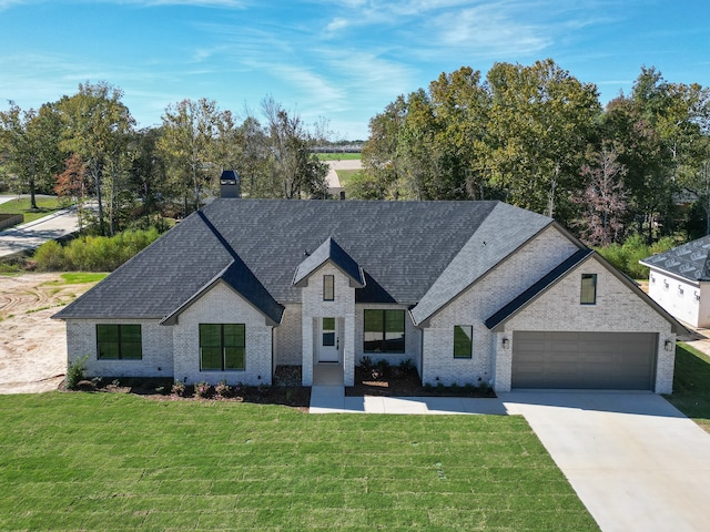 french provincial home with a garage and a front yard