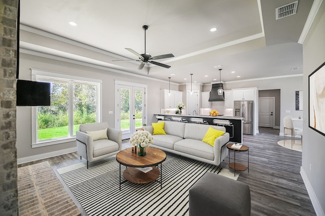 living room with ceiling fan, french doors, dark wood-type flooring, and ornamental molding