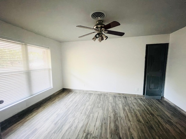 empty room with dark hardwood / wood-style floors and ceiling fan