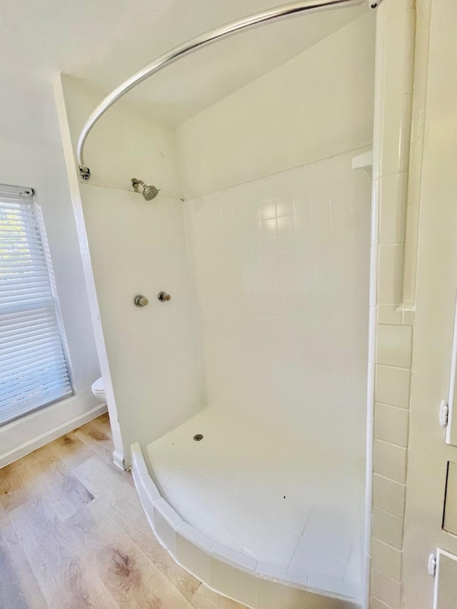 bathroom featuring toilet, wood-type flooring, and walk in shower