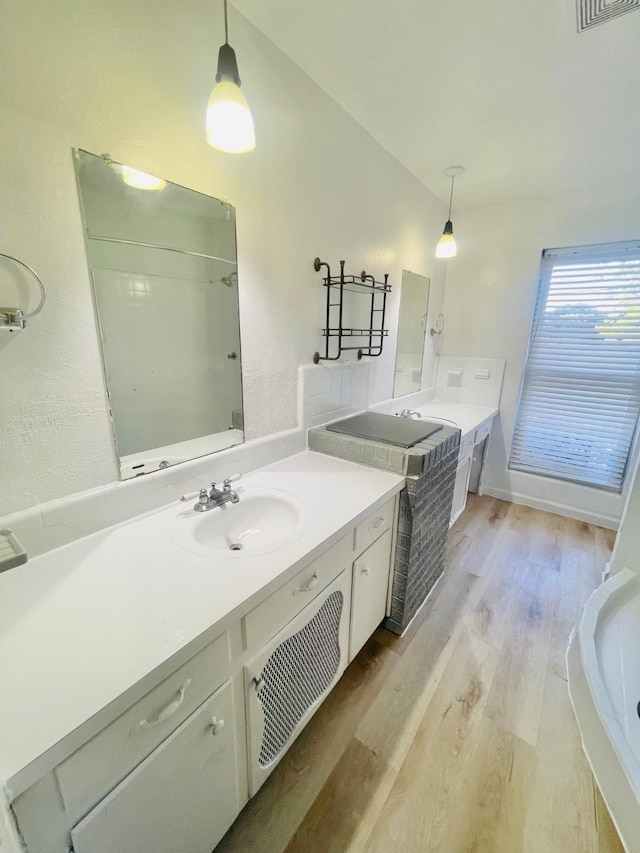 bathroom featuring vanity, hardwood / wood-style flooring, and vaulted ceiling