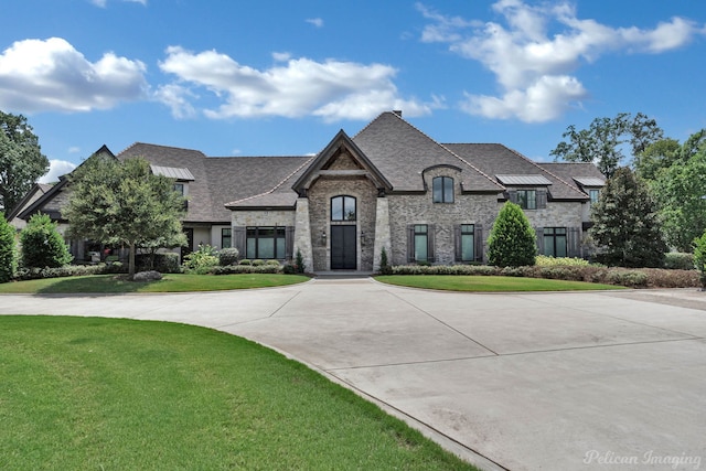 french provincial home featuring a front yard