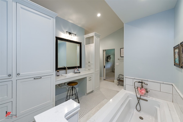 bathroom with vanity, tile patterned flooring, lofted ceiling, and a bath