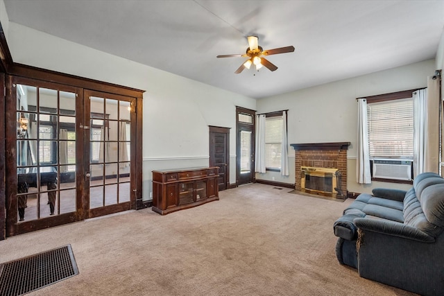 living room with french doors, ceiling fan, cooling unit, a fireplace, and carpet floors