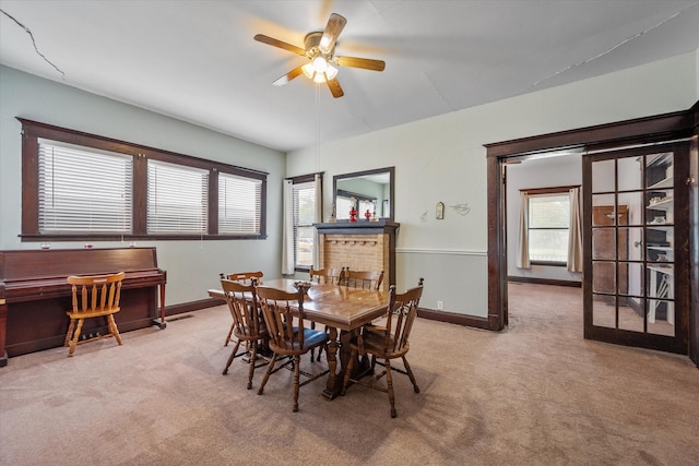 dining room with ceiling fan and light carpet