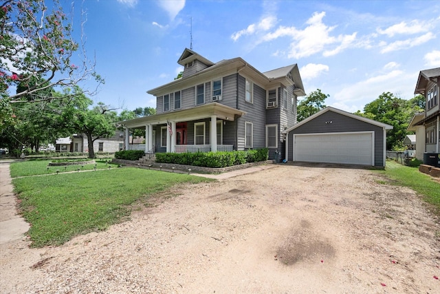 view of front of property with an outbuilding, a garage, a front lawn, and covered porch