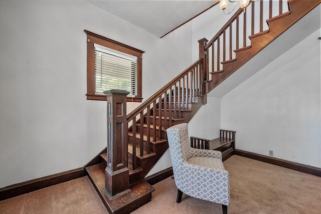 stairway with carpet floors, a chandelier, and a high ceiling