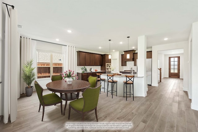 dining space with light wood-type flooring and a healthy amount of sunlight