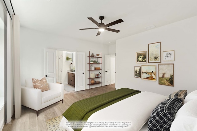 bedroom featuring light wood-type flooring, ensuite bath, and ceiling fan