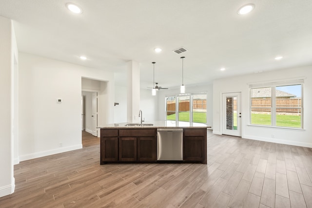 kitchen featuring dishwasher, light wood-type flooring, dark brown cabinets, decorative light fixtures, and sink