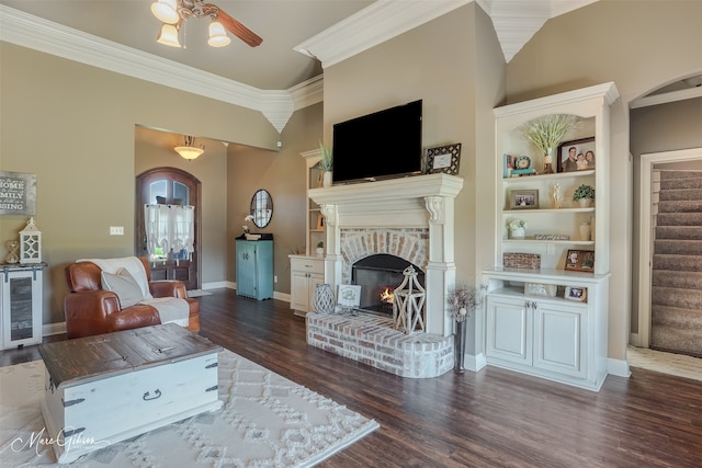 living room with dark hardwood / wood-style flooring, beverage cooler, crown molding, ceiling fan, and a fireplace