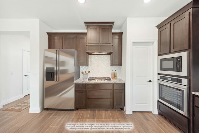 kitchen with light hardwood / wood-style flooring, dark brown cabinetry, appliances with stainless steel finishes, and light stone countertops