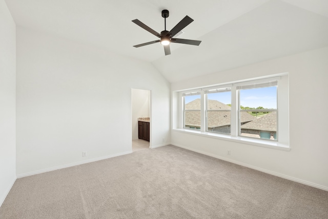 empty room with lofted ceiling, ceiling fan, and light carpet