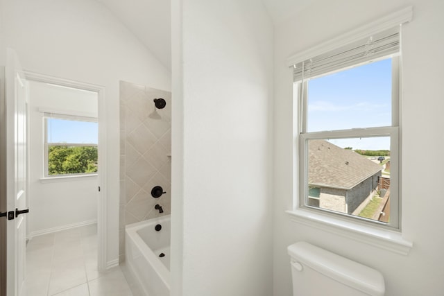 bathroom featuring a wealth of natural light, tiled shower / bath combo, and toilet