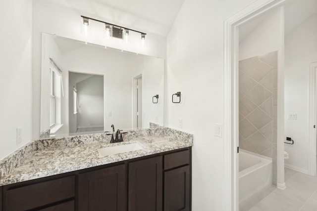 bathroom with a washtub, lofted ceiling, tile patterned floors, vanity, and toilet