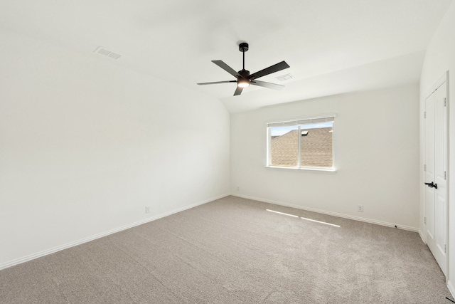 carpeted spare room featuring lofted ceiling and ceiling fan